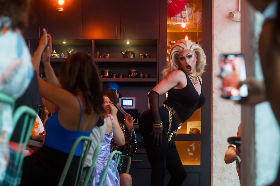 A drag queen poses for a crowd at a restuarant's drag brunch. 