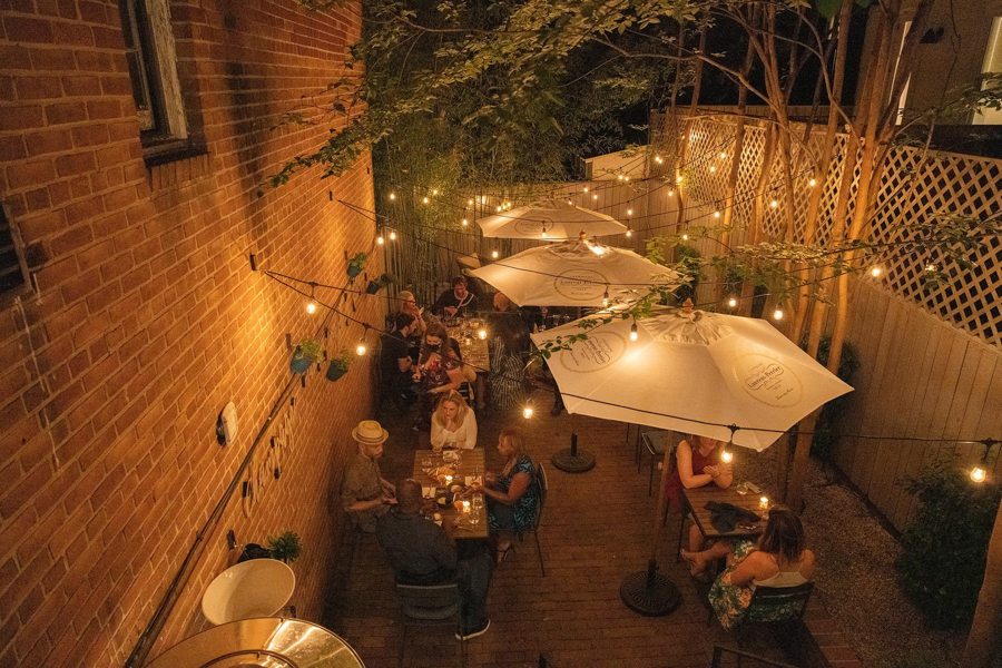 String lights and umbrellas create a romantic outdoor dining scene at Apéro in Washington, DC’s Georgetown neighborhood.