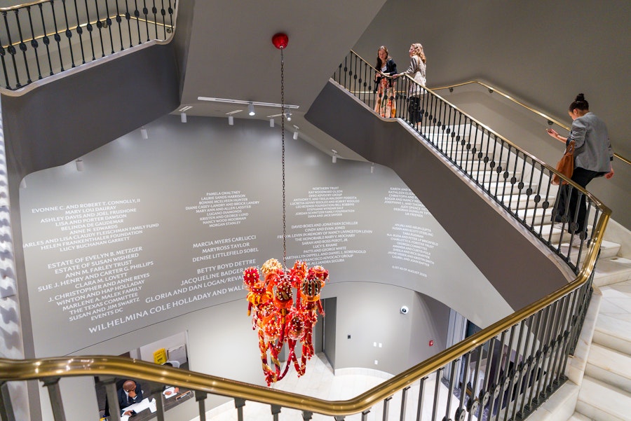 Visitors walk a marble staircase past a hanging art installation at the National Museum of Women in the Arts.