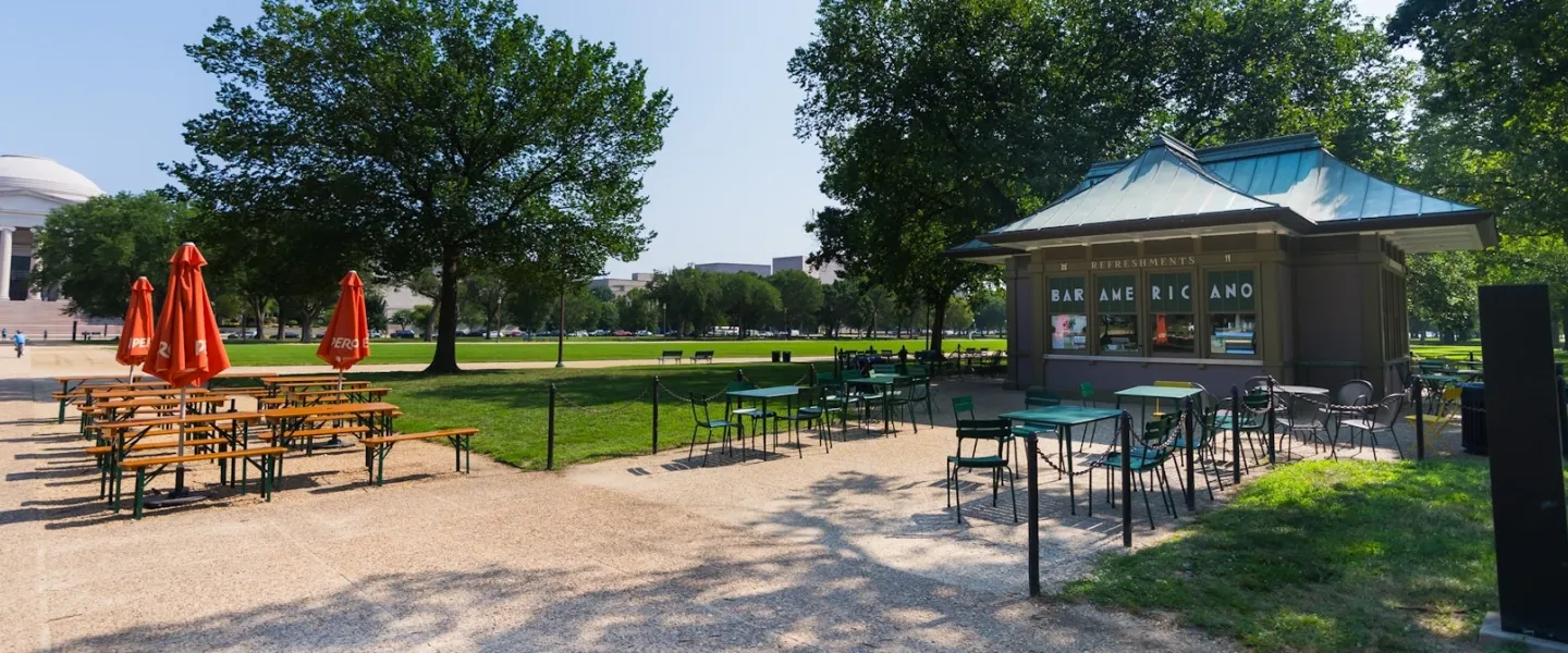 Outdoor tables and umbrellas surround the Bar Americano refreshment kiosk on the National Mall.