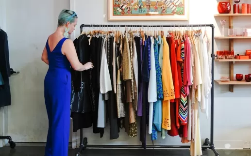 A stylish shopper browses a rack of colorful vintage clothing at a boutique in Washington, DC.
